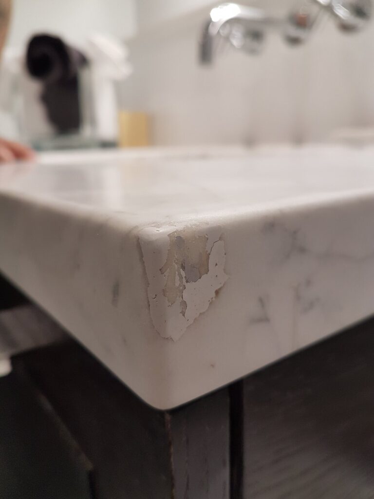 Chipped marble corner from a poor earlier repair, before restoration