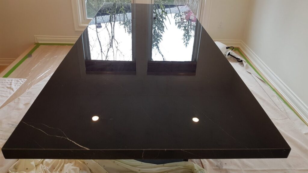 The same black marble table top after honing and polishing, with a mirror finish