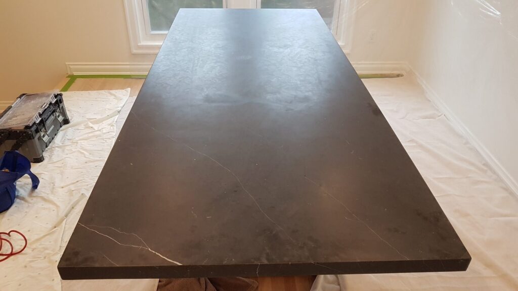 Black marble table top, dull and scratched, before polishing