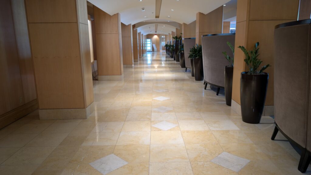 Polished stone corridor floor with inlaid diamond accents at the Westin Bayshore hotel in Vancouver, the ceiling lights reflected along its length