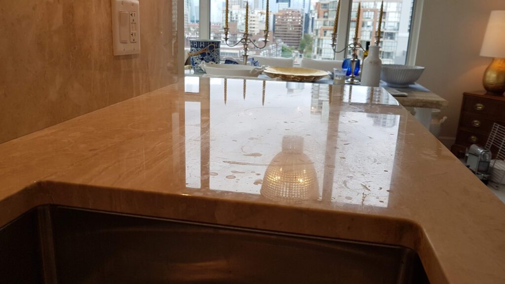 Marble kitchen counter in a Yaletown condo with dull etch spots across the surface, before restoration