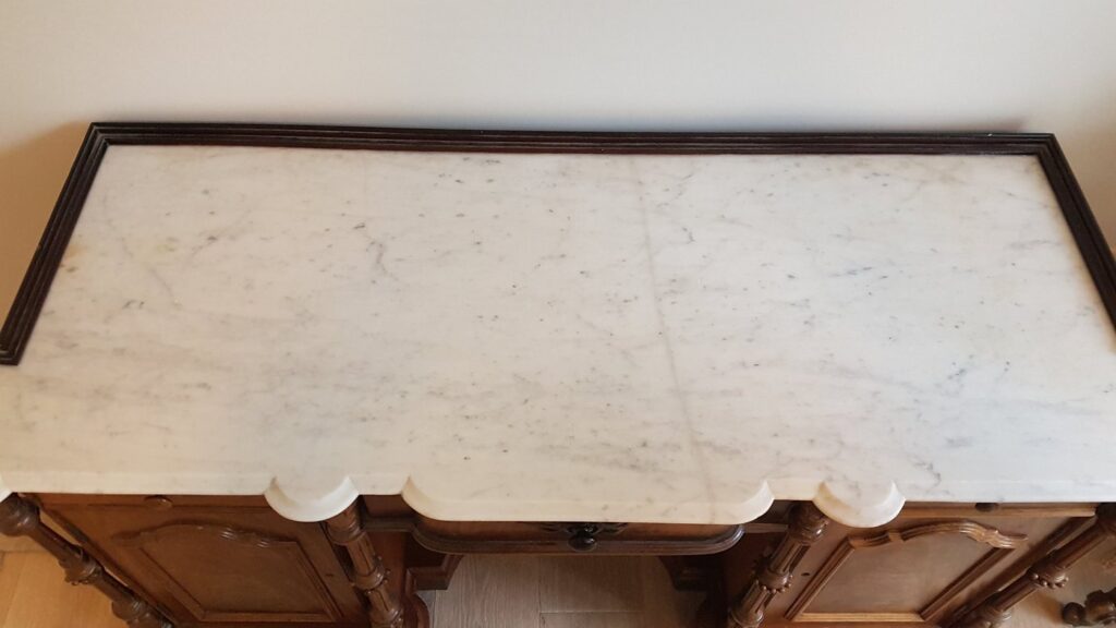 The same white marble top whole again on its antique cabinet after repair, the joins polished out