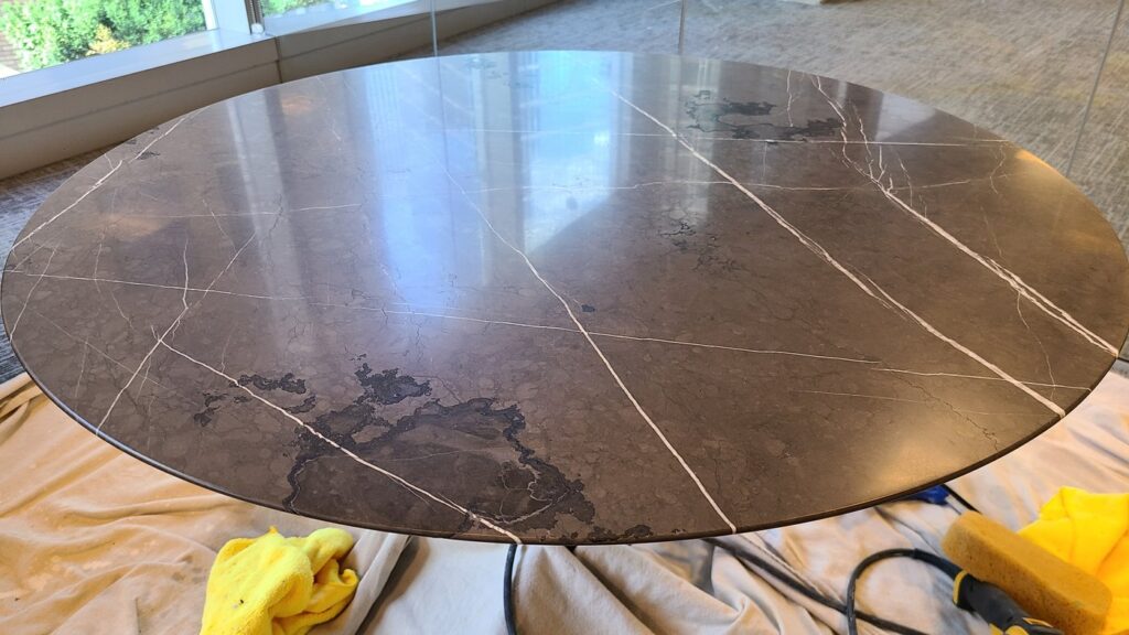 The same round marble table after repair, the edge complete and the top polished