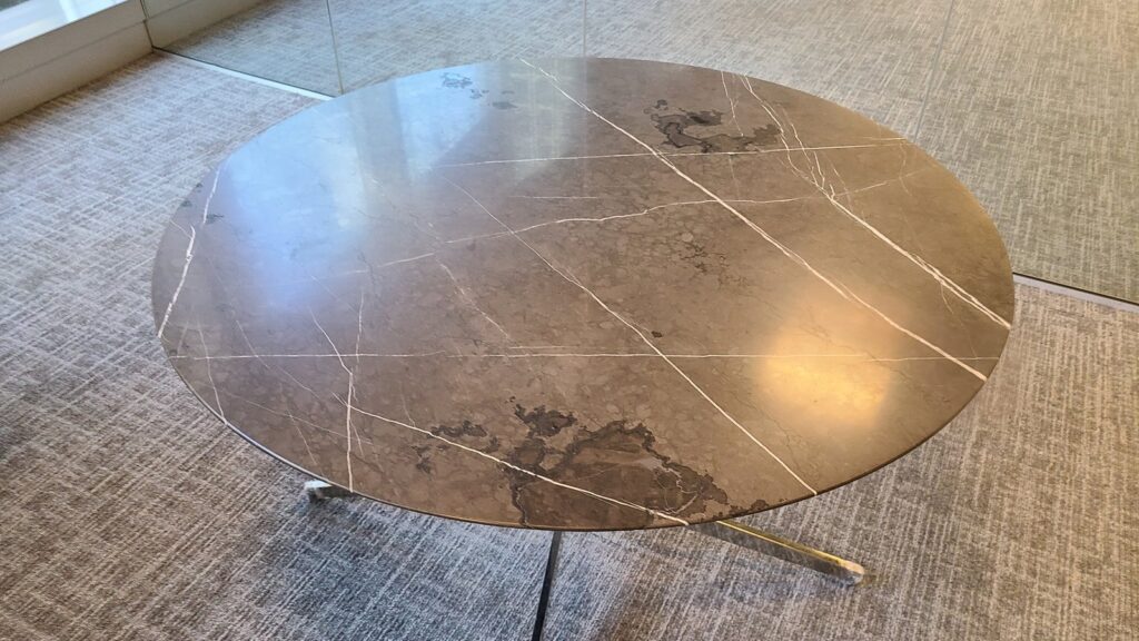 Round dark marble table after repair, the missing chunk rebuilt and the whole top polished