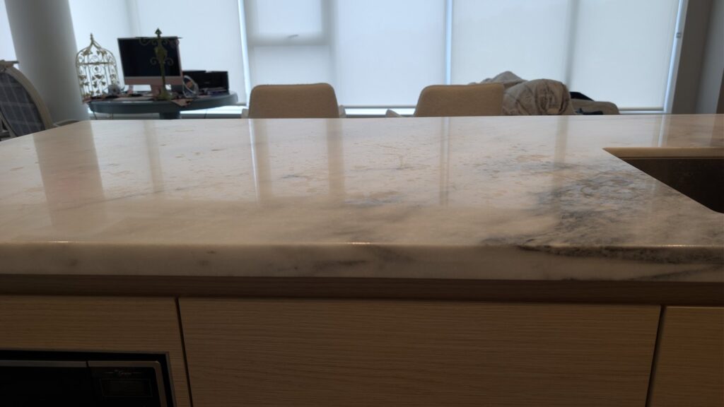 Marble kitchen island in a Port Moody home, cloudy and marked across the top, before restoration