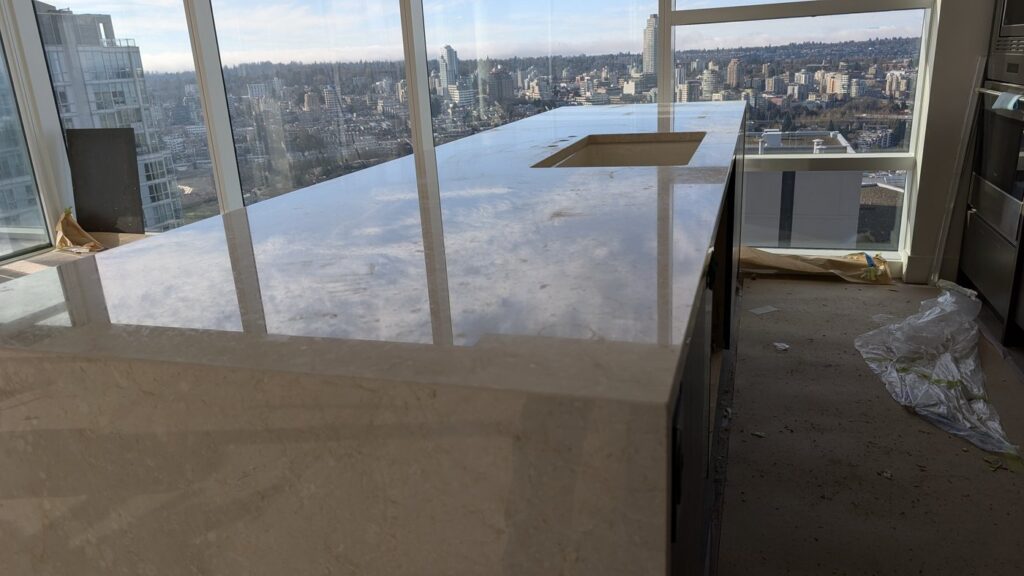 White marble kitchen island in a downtown Vancouver condo, flat and dull, before restoration
