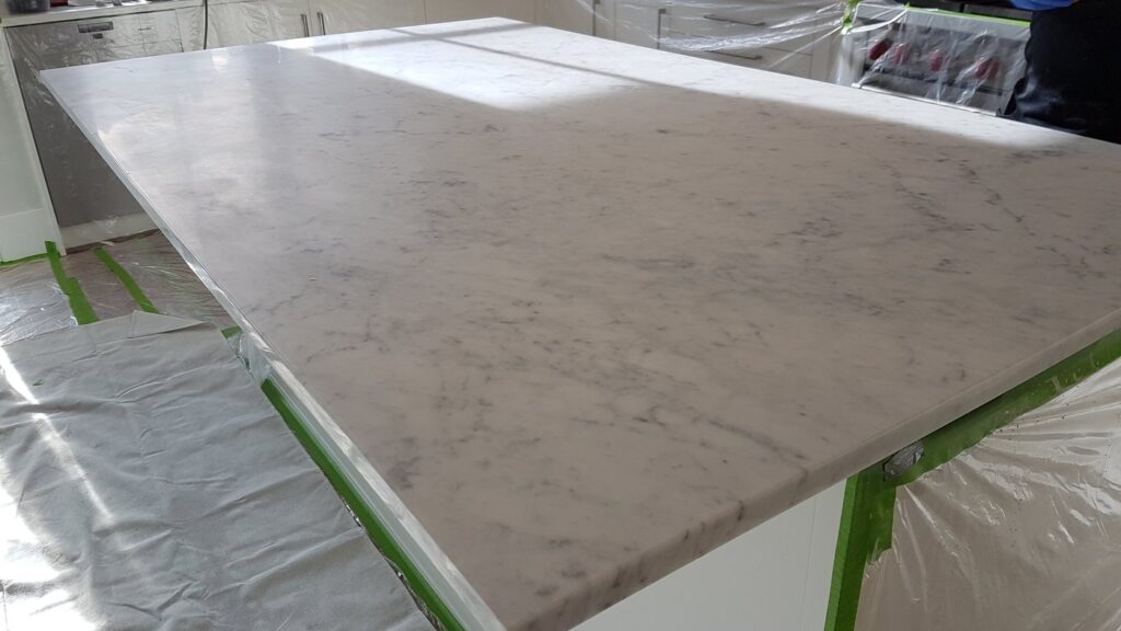 Marble kitchen island in a Richmond home with a dull, worn top, before restoration
