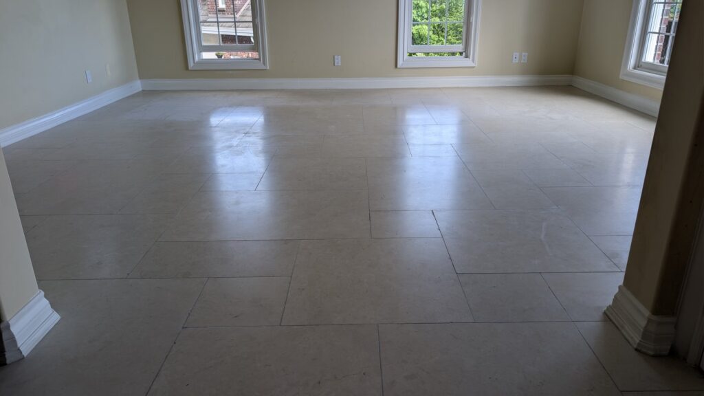 Marble floor in a West Vancouver sitting room, worn flat and dull, before restoration