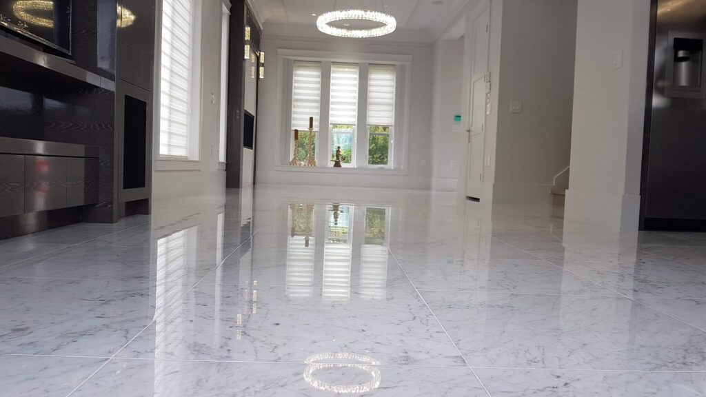 White marble floor in a Vancouver home after polishing, the hall and windows reflected in the surface
