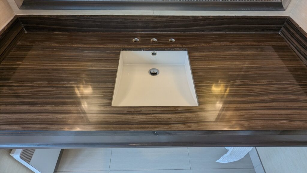 Striped stone vanity top in a Vancouver hotel room after restoration, polished around the basin