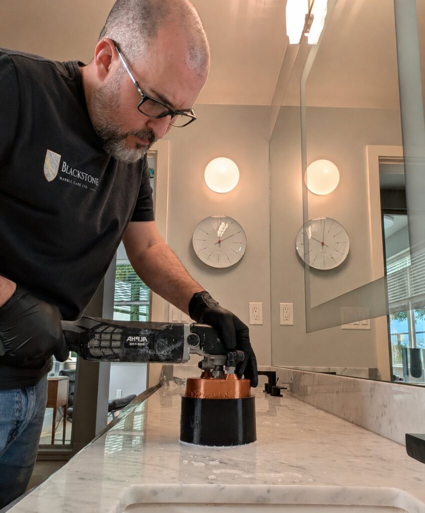 Rob Murray wet-polishing a marble vanity with a handheld tool