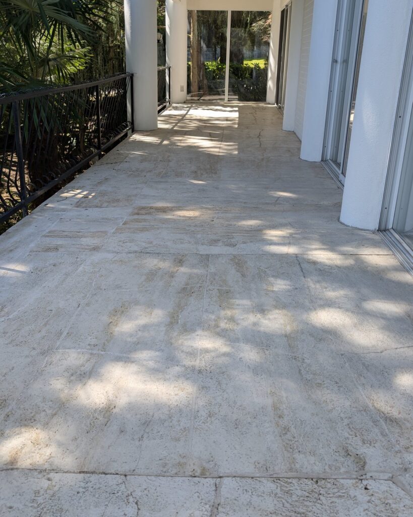 Covered travertine walkway along a Point Grey home, the stone dull and weathered, before restoration
