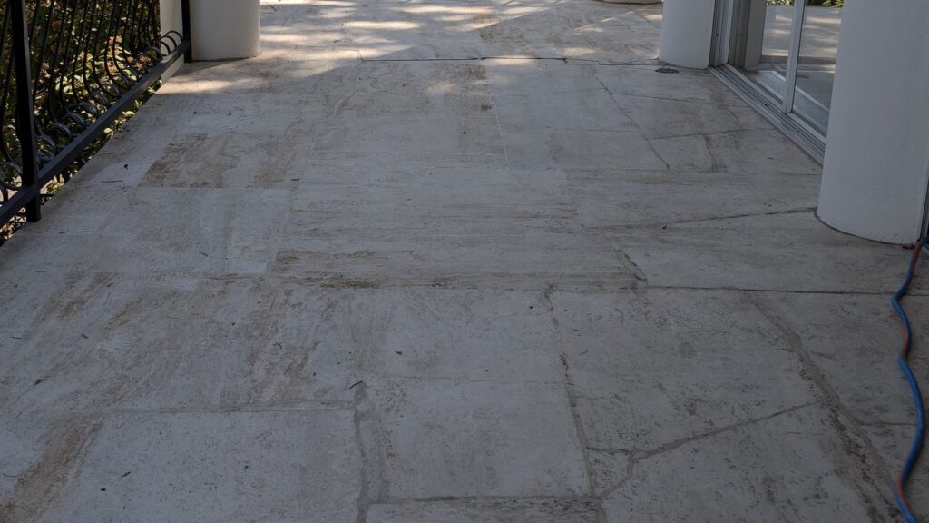 Travertine terrace floor in a Point Grey home, dry, dull and weathered, before restoration